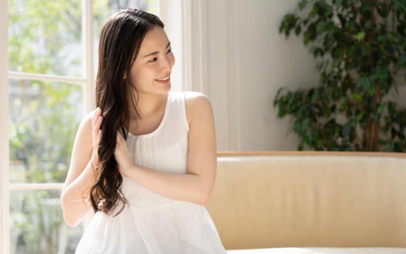 髪に触れるロングヘアの女性